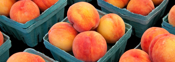 peaches in green cardboard baskets